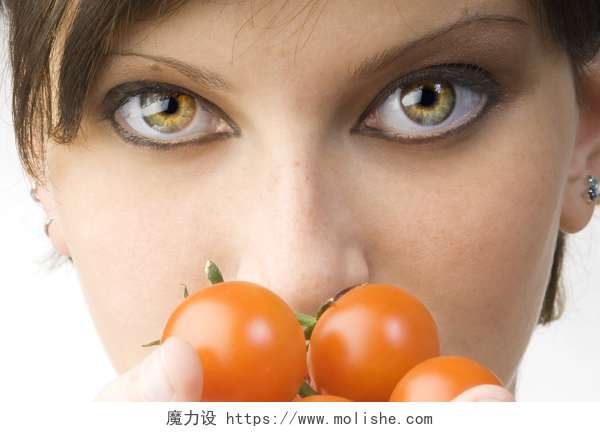 白色背景下拿着西红柿的女孩大眼睛和番茄